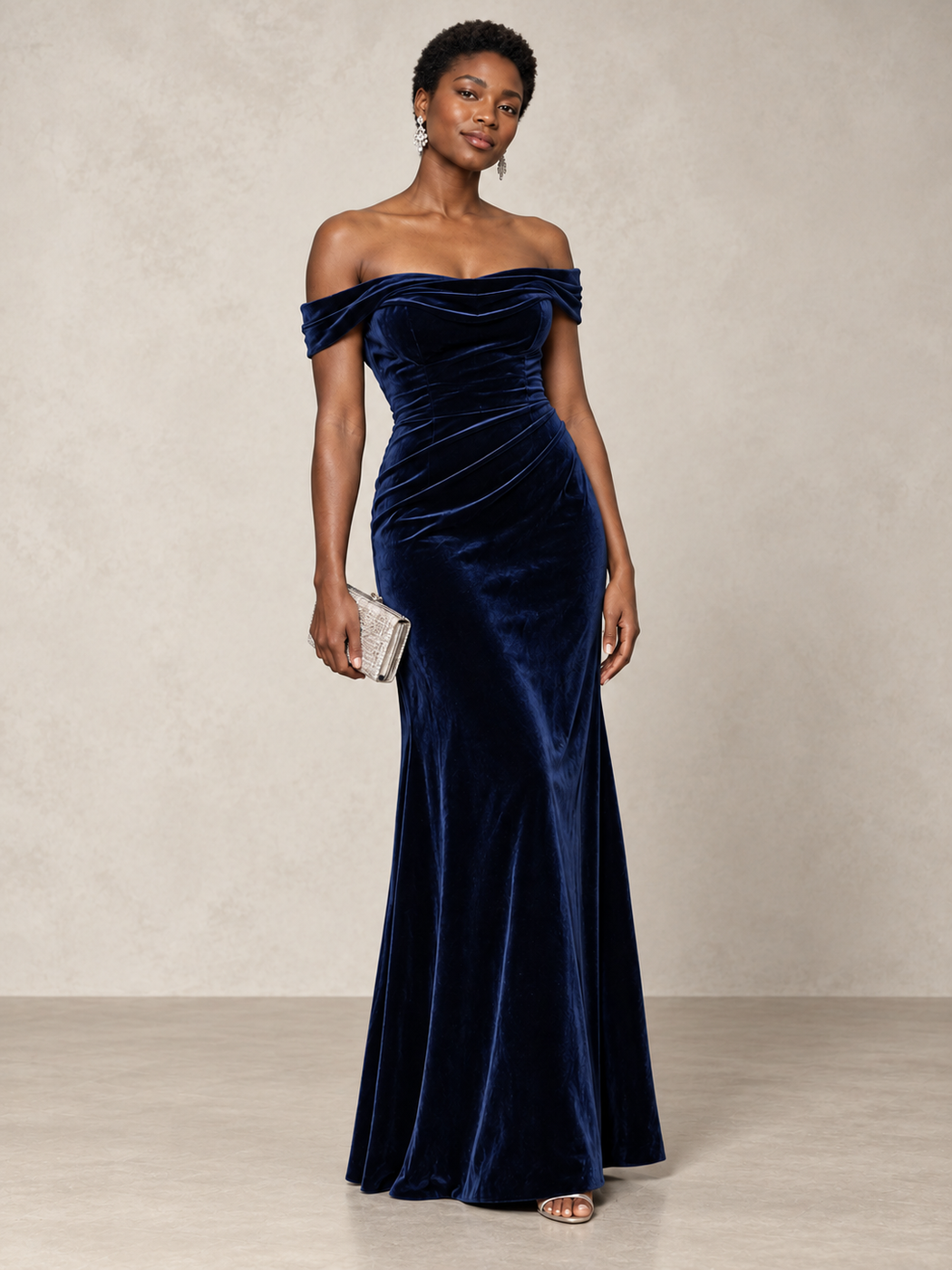 Navy velvet off-the-shoulder gown with a silver clutch