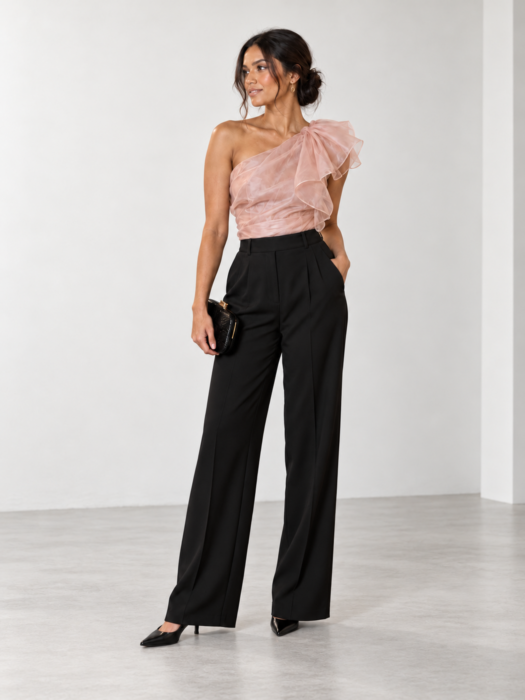 Blush one-shoulder ruffle top with black wide-leg trousers and black pointed heels