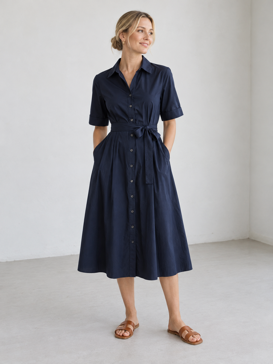 Navy short-sleeve shirtdress with a tie waist and tan leather sandals