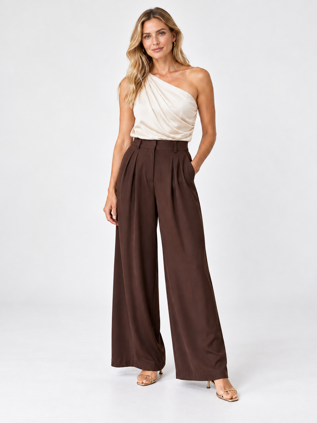 Ivory one-shoulder top with chocolate brown wide-leg trousers and nude sandals